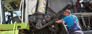 combine-machine-service-mechanic-repairing-motor-outdoors